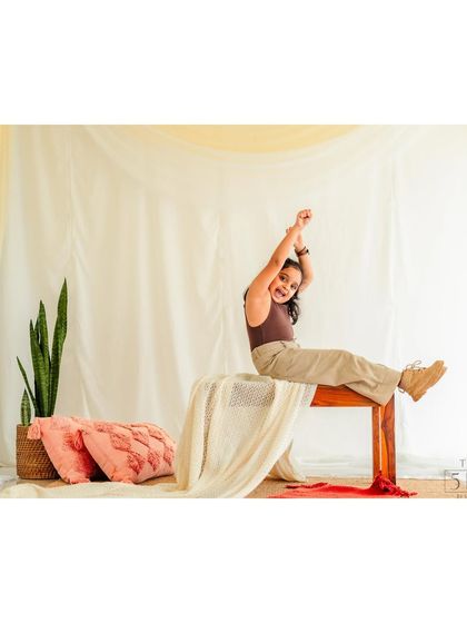 A fun, unposed shot of a girl stretching happily on a bench during her studio session. We let kids be kids, and often these in-between moments make for the most memorable portraits.