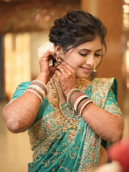 A candid moment of the bride getting ready, her makeup looking flawless and radiant.