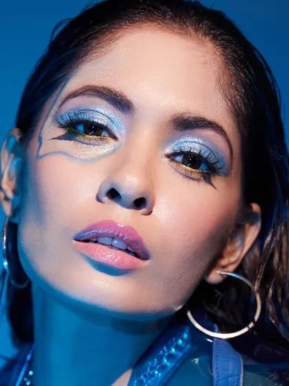A cool, icy blue eyeshadow look with a sharp graphic liner, showcasing a student's skill in creating clean, impactful makeup.