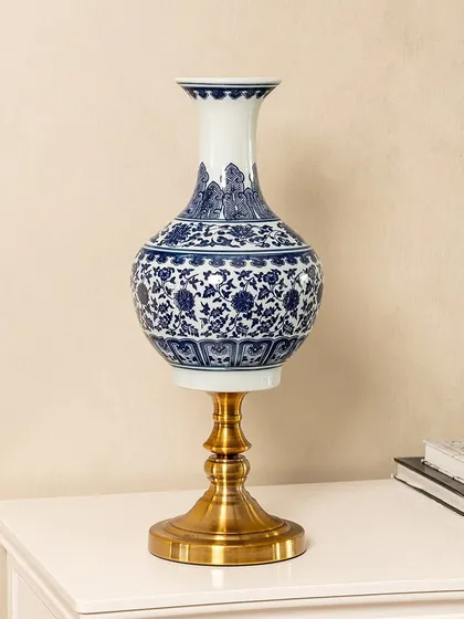 This blue pottery vase is a perfect example of the timeless craftsmanship I look for. The deep cobalt blue and intricate floral patterns are hand-painted, set on a modern brass stand to blend traditional art with contemporary design. It's a statement piece for any console or side table.