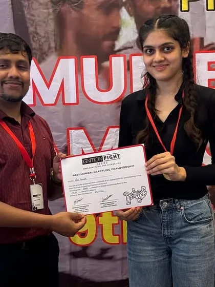Zene receiving her certificate after a second-round TKO victory. Her hard work and aggressive style paid off, earning her a well-deserved gold medal.