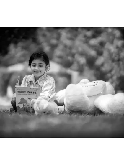 The black and white version of Brishka reading fairy tales. This edit gives the photo a nostalgic feel, like a cherished memory from childhood.