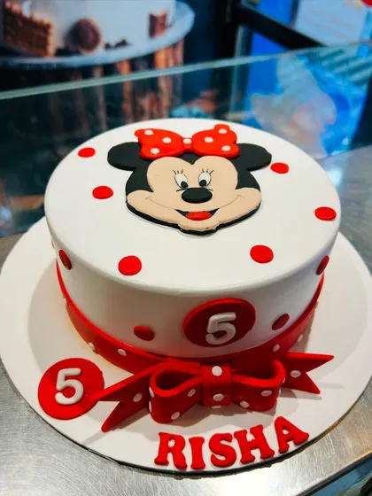 A classic Minnie Mouse cake with her signature red and white polka dots. The clean design is finished with a big red bow and the birthday girl's name, perfect for a 5th birthday.