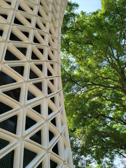 The VERTO tower is designed to integrate seamlessly into green urban environments. This shot captures the relationship between the man-made technological object and the natural elements surrounding it, a physical representation of our 'Symbiosis' philosophy.