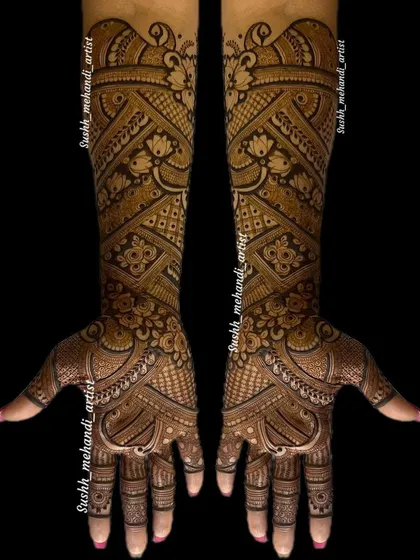 This is a very dense and intricate bridal design, where every space is filled with detail. The patterns flow beautifully from the fingers to the elbows.