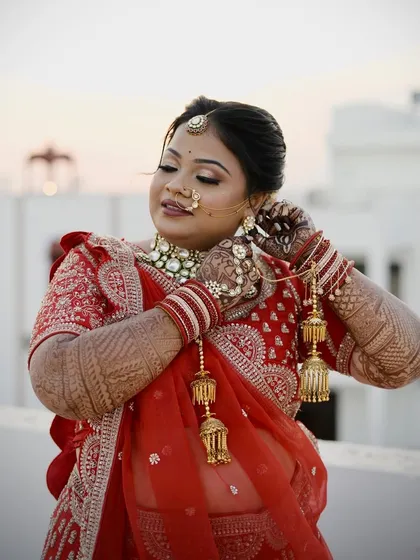 Adjusting her kaleeras. This candid shot shows the intricate henna, bridal bangles, and the perfectly draped lehenga.