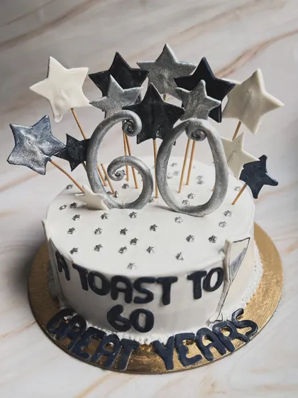 Another angle of our popular 60th birthday cake. The star toppers and silver details make it a festive centerpiece for any milestone celebration.
