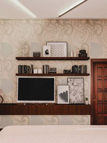 The TV and entertainment wall in the bedroom, featuring a floating console and open shelving against a subtly patterned wallpaper.