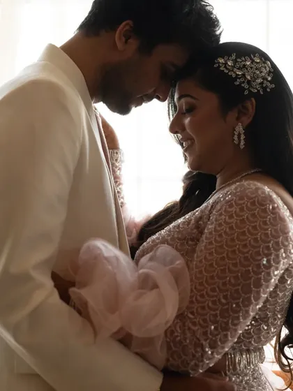 A beautifully lit close-up of the couple in an intimate embrace, highlighting the bride-to-be's sparkling hair accessory.