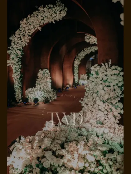 The full length of the enchanting floral tunnel, designed to transport guests into a different world. This kind of immersive decor is a hallmark of our sangeet and cocktail night designs.