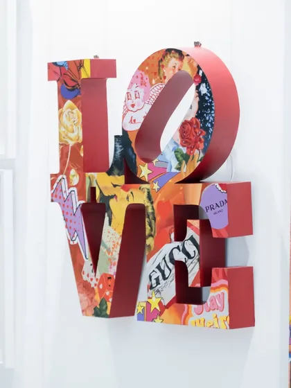A side view of "Love Unleashed," highlighting the vibrant red metal and the layered imagery that gives the piece its dynamic energy.