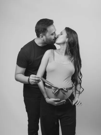 A gift of love, tied with a ribbon. This black and white shot is both playful and deeply intimate. It’s a beautiful way to symbolize the precious gift of life they are about to receive.