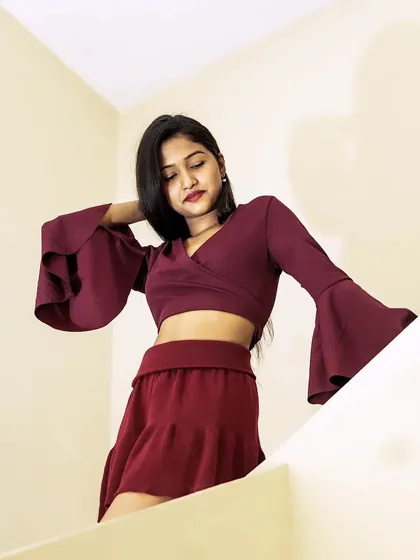 A creative angle from above, this shot focuses on the dramatic bell sleeves and the model's elegant pose.
