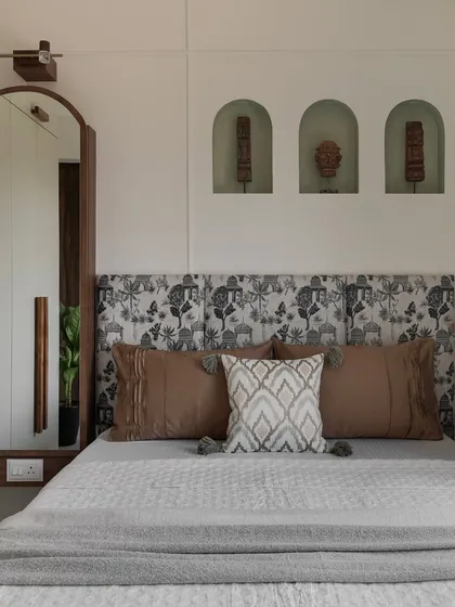 Your bedroom should be your personal sanctuary. We designed this space with a focus on tranquility, using a custom-printed headboard, earthy tones, and unique arched wall niches for a touch of personality and calm.