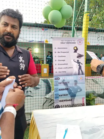 Explaining the key points of self-defense to parents and visitors at our event booth. Awareness is the first and most important step.