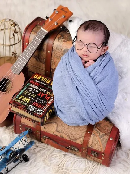 Another take on the creative newborn portrait. This little one is ready for an adventure, surrounded by vintage suitcases, an airplane, and a ukulele.
