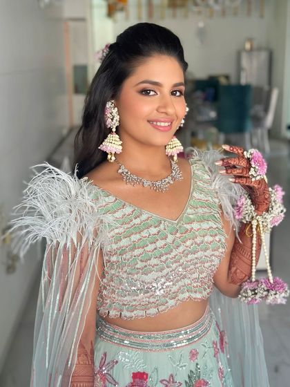 The complete look, with fresh floral jewelry adding a touch of whimsy to the glamorous makeup and outfit.