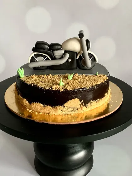 Vroom vroom, it's cake o'clock. This biker-themed cake features a hand-modelled motorcycle on a chocolate "dirt" road.