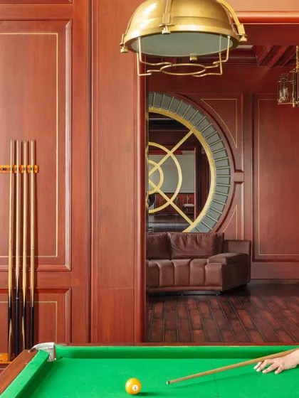A view of the billiards room in the Wanderlust Villa, looking through to the entertainment lounge. The rich wood paneling and classic design create a sophisticated and timeless atmosphere.