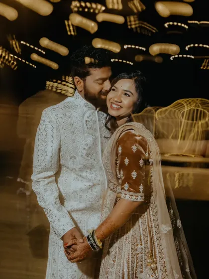 A candid moment of laughter and affection between the couple, captured with a slow shutter speed to create a beautiful light trail effect.