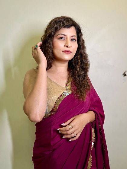 A thoughtful and elegant pose. The soft lighting enhances the subtle details of her makeup.