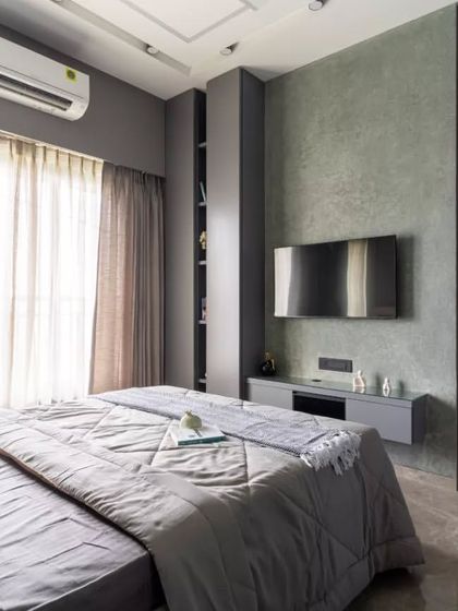 This modern bedroom exudes calm sophistication through its muted color palette and streamlined design. Every detail, from the minimalistic wall-mounted TV unit to the plush bedding, reflects a balance between functionality and comfort.