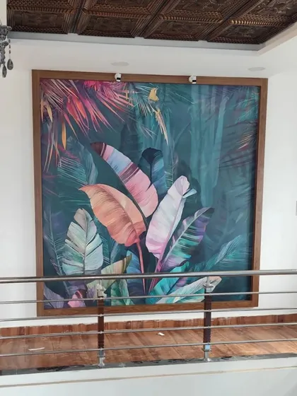 This large, framed wallpaper panel acts as a statement piece of art in a hallway. The vibrant, multi-colored leaf design brings a powerful splash of color to the neutral space.