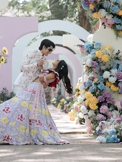 A playful dip amidst a carnival of flowers. This shot is all about capturing the fun and vibrant energy of pre-wedding festivities, where every moment is a celebration of love and laughter.