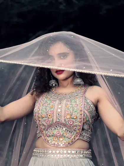 A playful shot showcasing the beautiful blouse and sheer dupatta. Our party wear lehengas are designed to make you feel confident and glamorous.