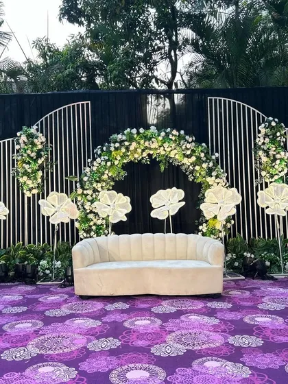 Another angle of the Indian stage decor, showcasing the balance of floral elements and modern lighting. The design creates a beautiful frame for the main seating area.