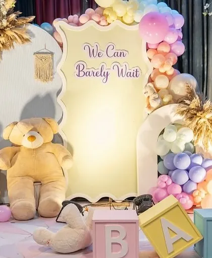 A 'beary' special baby shower in dreamy pastels. This setup features a large custom backdrop, a giant cuddly teddy bear, and a rainbow of soft-colored balloons for a sweet and gentle celebration.