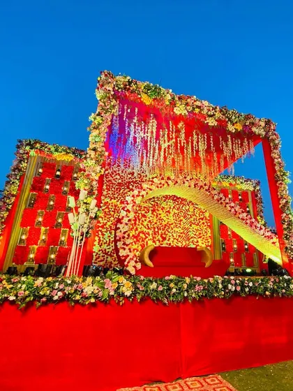 A daytime view of the unique red floral stage, showing the vibrant colors against the blue sky.