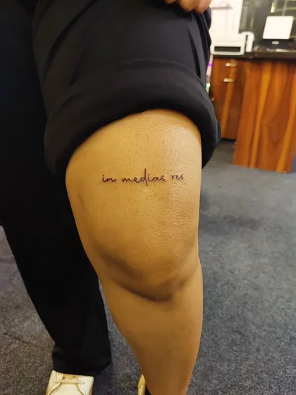 The Latin phrase 'in medias res' (in the middle of things) tattooed above the knee. A unique and intellectual piece for lovers of literature and storytelling.