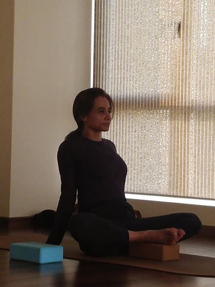 Using yoga blocks to support the hips in a seated posture. This simple adjustment can dramatically improve comfort and alignment, allowing for a deeper meditative state.