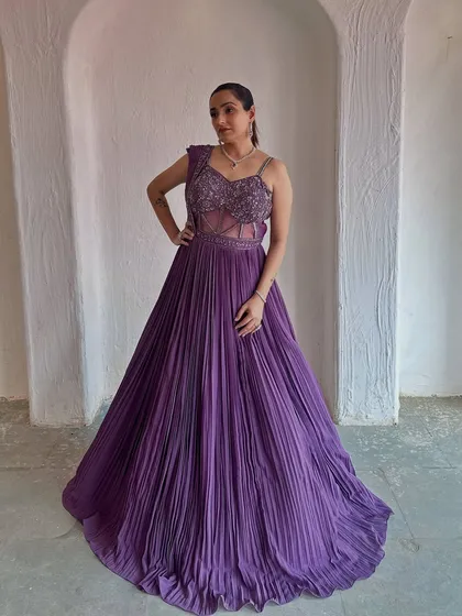 This deep purple gown with a pleated skirt and embellished bodice is a true showstopper. It's a perfect rental for a glamorous evening event.