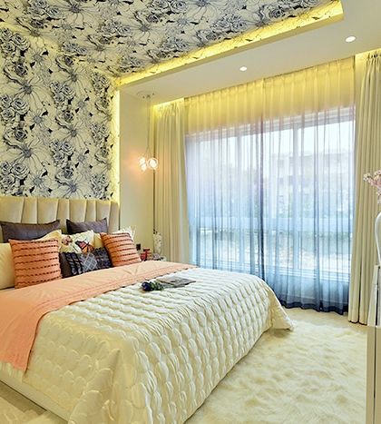 The brief for this bedroom was "elegant and eye-catching." We achieved this by pairing a dramatic floral wallpaper on the ceiling with soft, off-white walls and luxurious upholstery, creating a truly stunning space.