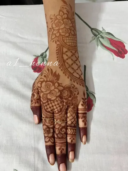 A close-up of one hand, showing the detailed floral patterns and the beautiful, even stain from my organic henna.