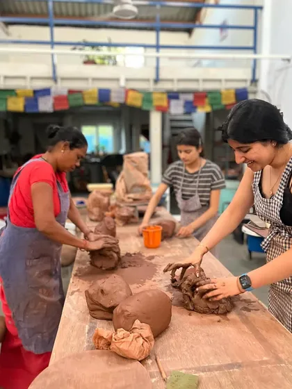 The large wooden tables are perfect for hand-building projects. Here, students are wedging clay, getting it ready for sculpting and shaping. It's a space for both individual work and collaborative energy.