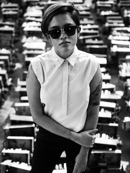 A strong, androgynous look captured in black and white. The high-contrast lighting and graphic background make this a powerful and modern portrait.