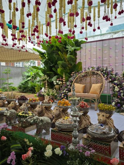 A close-up of the offering table at the outdoor baby shower, showing the cow props and silver elephants.