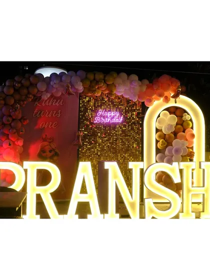 Another view of Pranshi's dazzling birthday stage, showing the illuminated archway and character cutout.
