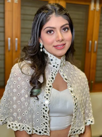 A portrait of the bridesmaid with a pop of green from her earrings. The makeup is kept neutral to allow the accessories to shine.