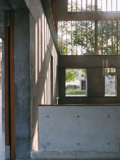A view from within the Lilavati Lalbhai Library, looking out into the campus courtyard. The design uses large glass panels and open sightlines to ensure the subterranean spaces feel connected to the outdoors and the life of the university.