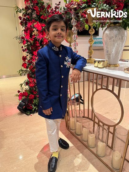 Standing tall and proud in our hand-worked blue sherwani. The full-length view shows the impeccable fit and elegant design, making it a perfect choice for a wedding reception or sangeet night.