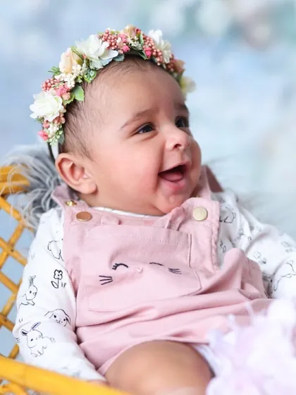 This image is all about capturing pure, simple joy. The floral crown adds a delicate touch to this classic newborn portrait.