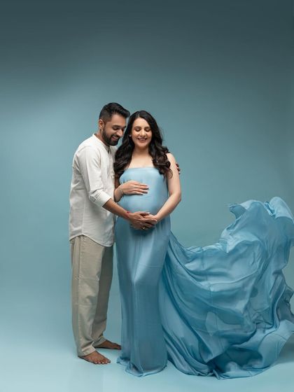 Another lovely shot of the couple with the blue gown, capturing their happy smiles and the beautiful movement of the fabric.