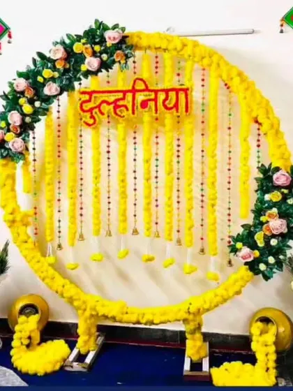 A festive "Dulhaniya" backdrop with a circular marigold frame. The decor includes decorative matkas and colorful hangings, perfect for the bride's pre-wedding functions.