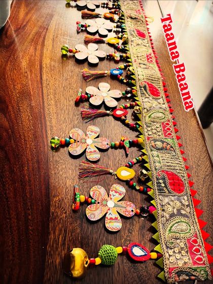 A side view of the 'Taana Baana' toran, highlighting the rich texture of the paisley lace and the colorful beads.