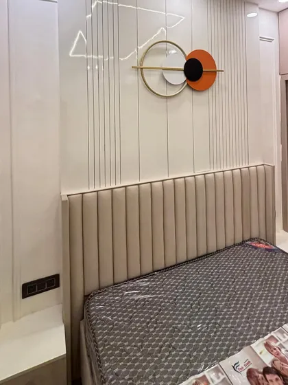 This bedroom features a vertically fluted headboard and a matching wall panel with a contemporary art piece. The neutral color palette and clean lines give the room a sophisticated and calming feel.
