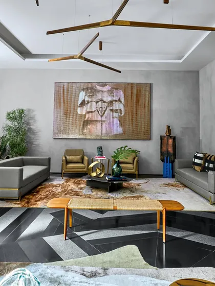The living room at the Baid Residence, featuring a custom woven bench from Phantom Hands and a large artwork by Justin Ponmany. The chevron-patterned floor adds a bold graphic element to the space.